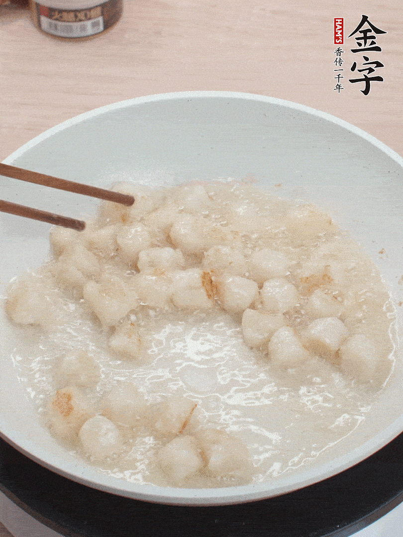 油溫4成熱，鮮貝蘸干淀粉下鍋煎，一面微黃后翻面。