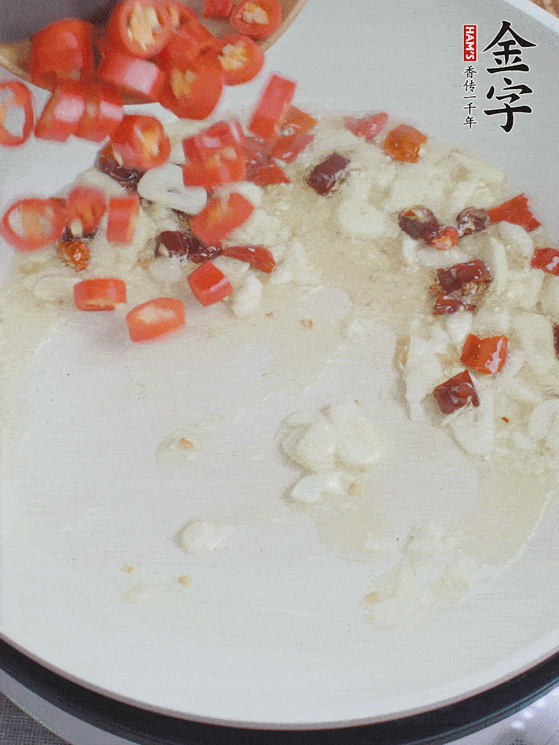 油6成熱，下蒜末、干紅辣椒煸炒，出香味后再放美人椒、香腸。