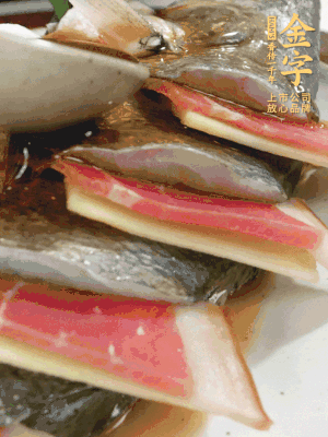魚肚中塞蔥結(jié)、火腿片，魚身上碼放姜片、火腿片，倒入混合的料汁。