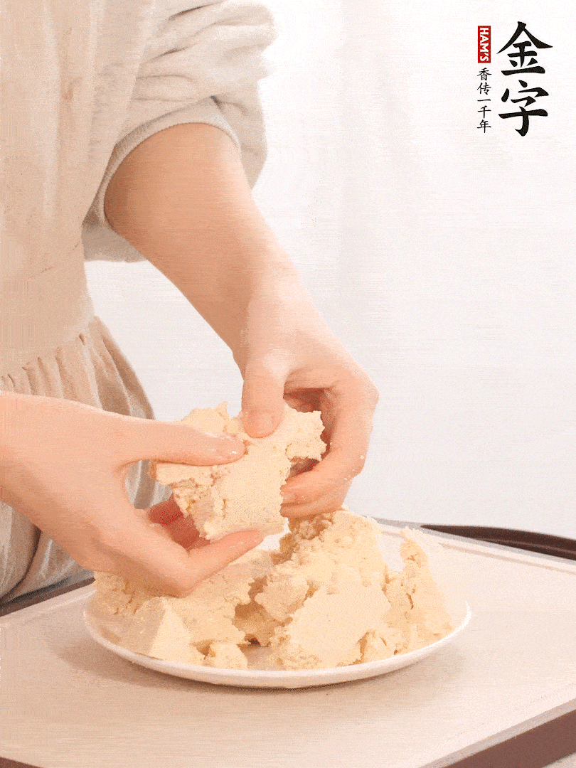 老豆腐用手掰成塊。